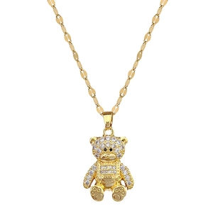 Luxurious gold bear pendant necklace with white crystals on a flat bamboo chain links