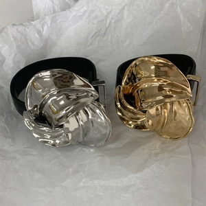Detail van de metalen bloemgesp en zwarte lederen band in goud en zilver kleur