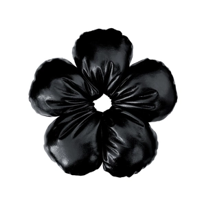 Close-up of a black five-petal flower hair scrunchie in premium shiny faux leather