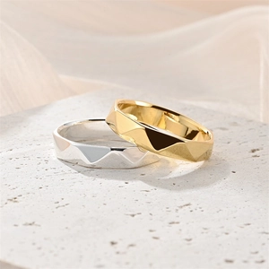 Dettaglio macro di anelli di coppia con sfaccettature geometriche in oro e argento