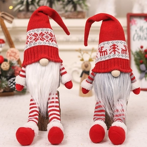 Close-up of long-legged Christmas gnomes in red knitted hats and plush white beards