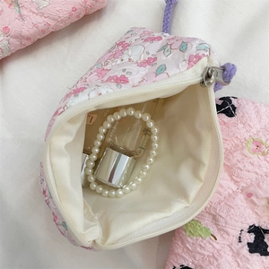 Detail of pink floral quilted pouch with a zipper opening and soft fabric texture