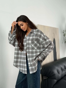 Close-up of black and grey plaid shirt with single chest pocket and button-down details