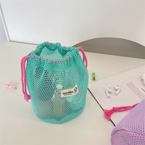 Close-up of mint green mesh drawstring bag with pink cord and brand woven label