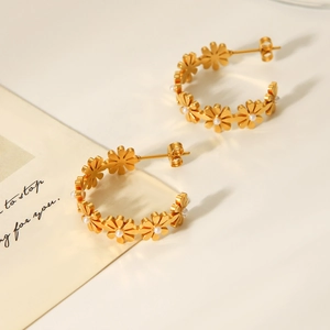 Detail of 18K gold stainless steel hoop earrings with white pearls and flower design