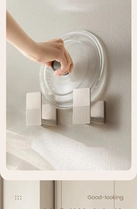 Wall-mounted off-white pot lid holder rack with textured design for kitchen storage