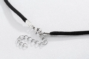 Detail of black braided cord necklace with adjustable silver lobster clasp and chain
