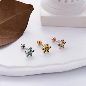 Macro detail of leaf-shaped stainless steel earrings with green zircon and screw backs