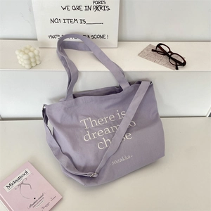 Lavender canvas tote bag detail featuring white inspirational text and dual strap design