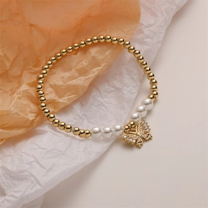 Detailed view of a gold beaded bracelet featuring a delicate butterfly charm and pearls