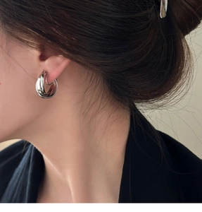 Gros plan de boucles d'oreilles géométriques argentées à triple couche pour un look épuré