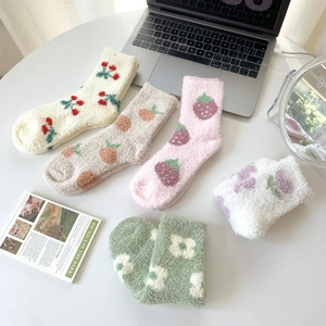 Flat lay of five pairs of warm coral fleece socks with colorful fruit and flower patterns