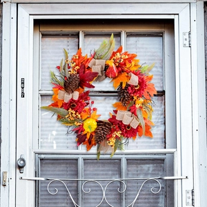 Autumn wreath with red sunflowers, pine cones and pumpkins for front door decor