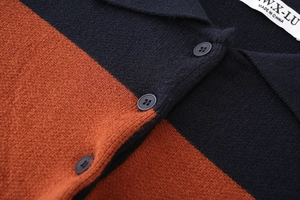 Detail of color-block knit polo with navy blue and caramel stripes and three buttons