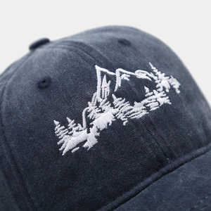 Detailed close-up of mountain and forest embroidery on navy vintage cotton baseball cap