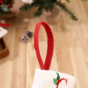 Knitted red and white Christmas stocking ornament with festive embroidery detail