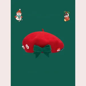 Detailed view of red wool beret with dark green bow and festive 3D Christmas charms