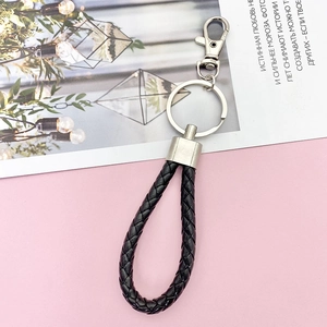 Detail of black braided leather keychain with silver metal ring and lobster clasp fastener