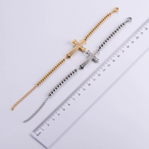 Close-up of gold and silver beaded cross bracelets with length measurement guide