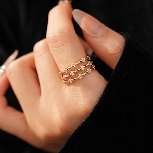 Macro shot of gold bamboo joint triple-layer ring featuring pavé set zircon accents