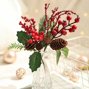 Artificial Christmas pine cones with red berries in glass vase for holiday home decor
