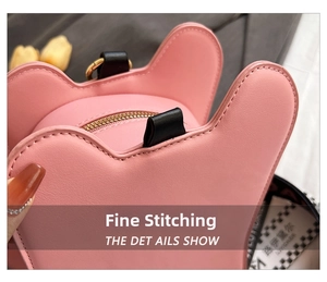 Detailed macro view of pink bear bag stitching, zipper closure, and black top handle grip