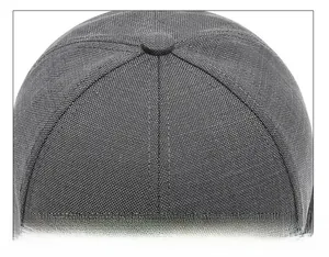 Détail de la technique de couture précise sur une casquette grise avec texture de tissu