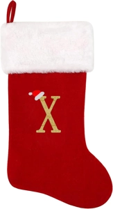 Detail of red Christmas stocking with white faux fur and golden glitter letter X with hat