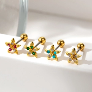 Golden stainless steel cartilage studs with colorful zircon flower design on white surface