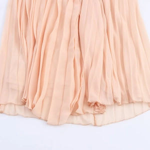 Detailed close-up of light pink pleated midi dress hem with delicate chiffon texture