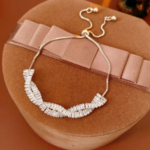 Détail d'un bracelet en chaîne argentée avec zircons sur une boîte à bijoux en velours brun