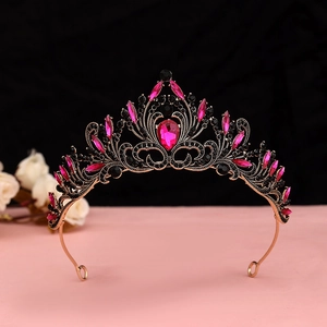 Detailed close-up of baroque crown with black crystals and pink teardrop gemstones
