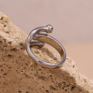 Dettaglio macro dell'anello a fascia d'argento lucido su una base di pietra naturale