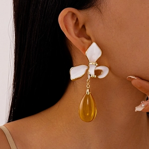 Close-up of vintage flower earrings with amber teardrop pendants on a model
