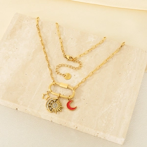 Detailed shot of 18K gold-plated stainless steel paperclip necklace with star and moon charms