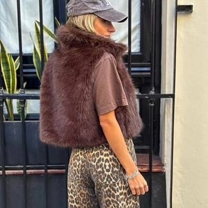 Gilet da donna in ecopelliccia marrone scuro stile corto vista laterale posteriore