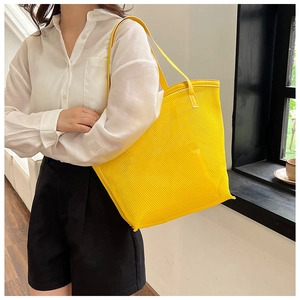 Detail of yellow mesh beach tote bag featuring durable hollow PVC grid and shoulder strap