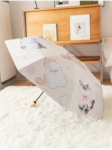 Detail of white cat pattern umbrella with a premium wooden handle on a plush carpet