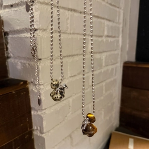 Close-up of tiger eye and marble stone pendants on silver metal ball chains