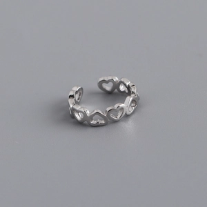 Macro detail of adjustable silver heart-shaped chain ring with polished hollow design
