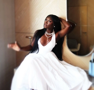 Detail of multi-layer pearl necklace paired with a white halter neck dress on a model