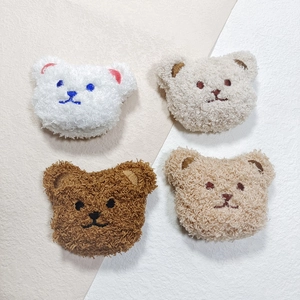 Detail of four colorful plush bear heads with embroidery for DIY crafts and accessories