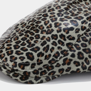 Macro detail of leopard print PU leather beret with white stitching and textured finish