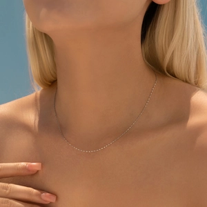 Minimalist S925 sterling silver chain necklace for women worn against a blue sky