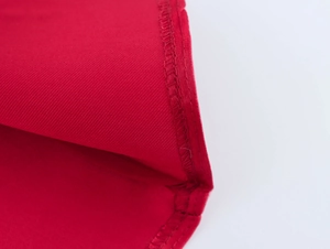 Gros plan sur la texture du tissu rouge et les coutures détaillées de la robe