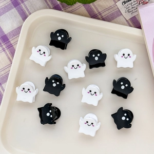Detailed view of mini ghost hair claws in black and white on a purple plaid background