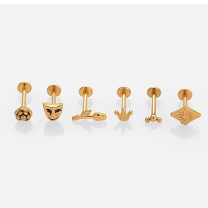 Vue détaillée de six piercings en acier inoxydable 316L doré sur une surface blanche