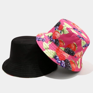 Detail of reversible bucket hat showing vivid fruit pattern and solid black cotton fabric