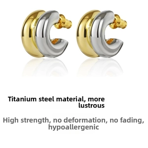Macro detail of high-polish titanium steel double-layer two-tone hoop earrings