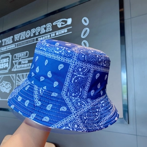 Detail view of blue paisley bucket hat with white pattern and premium glossy fabric